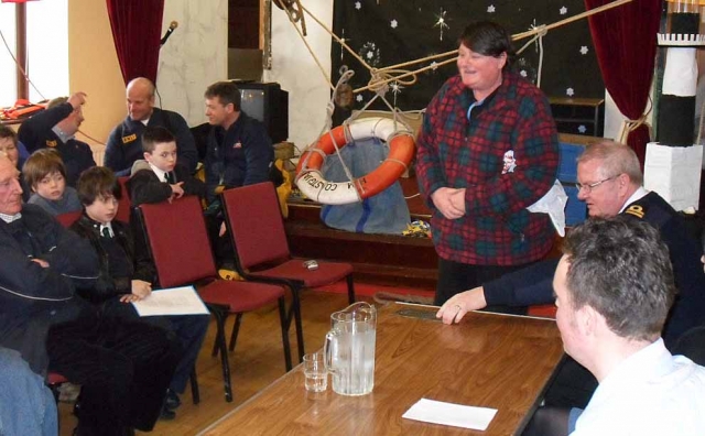 Teresa McFaul presents the recently discovered original brass plaque awarded to the rescuers.